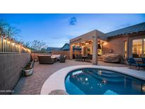 Inviting backyard featuring a covered patio, outdoor kitchen, cozy seating around a fire pit and a sparkling pool at 3521 N Barron --, Mesa, AZ 85207