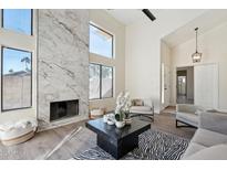 Bright living room with marble fireplace, high ceilings, and modern decor at 4024 E Hiddenview Dr, Phoenix, AZ 85048