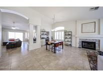 Open living room featuring a fireplace, dining area, and neutral color palette at 4558 E Libby St, Phoenix, AZ 85032