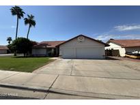 Charming single-story home with a red tile roof, green lawn, and a spacious two-car garage at 5709 E Fox St, Mesa, AZ 85205