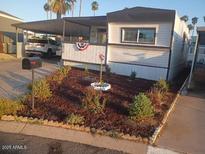 Charming single story home featuring manicured flower beds and a covered parking area at 701 S Dobson Rd # 438, Mesa, AZ 85202