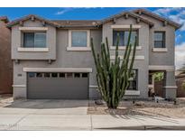 Two-story home featuring a two-car garage, landscaped front yard, and Southwestern desert flora at 7308 S 29Th Ln, Phoenix, AZ 85041