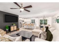 Open-concept living room flows into the kitchen with stainless steel appliances and a kitchen island with bar seating at 8437 E Bonnie Rose Ave, Scottsdale, AZ 85250