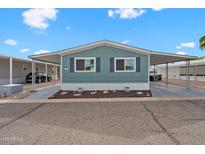 Charming home featuring an inviting covered parking area with landscaping and blue exterior paint at 8600 E Broadway Rd # 30, Mesa, AZ 85208