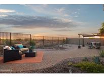 Expansive back patio with desert landscaping, wrought iron fence and comfortable seating, perfect for outdoor living at 10109 E Trailhead Ct, Gold Canyon, AZ 85118