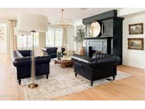Cozy living room with leather chairs, a fireplace, and a decorative rug on hardwood floors at 10344 E Trillium Ave, Mesa, AZ 85212