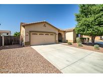 Charming single-story home with a well-manicured lawn, three-car garage, and a cozy entryway at 17985 W Ivy Ln, Surprise, AZ 85388