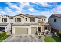 Charming two-story home featuring a stone facade, two-car garage, and well-maintained front yard at 22771 N 98Th Dr, Peoria, AZ 85383
