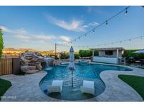 Resort-style pool with a waterfall feature, a swim-up bar, and comfortable lounging area at 22771 N 98Th Dr, Peoria, AZ 85383