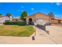 Charming single-story home with well-manicured lawn, desert landscaping, and boat parked in the driveway at 3237 W Angela Dr, Phoenix, AZ 85053