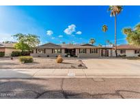 Charming single-story home with desert landscaping, complemented by palm trees and a wide driveway at 3710 E Mercer Ln, Phoenix, AZ 85028