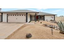 Charming home featuring a two-car garage and desert landscaping with a red front door, creating a welcoming curb appeal at 3973 W Hearn Rd, Phoenix, AZ 85053