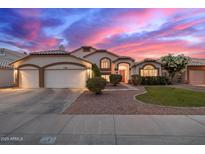Charming home showcasing a well-manicured front yard and an attached two-car garage under a colorful dusk sky at 1146 W Sea Fog Dr, Gilbert, AZ 85233