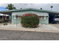 Charming mobile home featuring covered parking, well-kept landscaping, and quaint shutters at 120 N Val Vista Dr # 151, Mesa, AZ 85213
