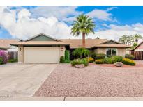 Charming single-story home featuring well-kept landscaping, a two-car garage, and a beautiful palm tree at 15424 N 52Nd Pl, Scottsdale, AZ 85254
