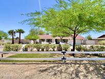Charming single-story home features a white fence, desert landscaping, and mature trees at 15602 N 37Th St, Phoenix, AZ 85032