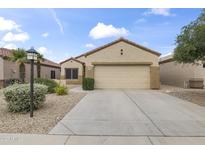 Inviting single-story home featuring a two-car garage, neutral stucco, and low-maintenance desert landscaping at 15822 W Alpine Ridge Dr, Surprise, AZ 85374