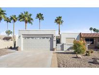 Charming single-story home featuring desert landscaping, palm trees, and a two-car garage at 17019 E Calaveras Ave, Fountain Hills, AZ 85268