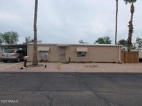 Tan single-story home with gravel yard and covered parking area showcasing a tidy and low-maintenance front at 200 E Ivanhoe St, Chandler, AZ 85225
