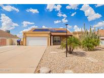 Charming single-story home with solar panels, a two-car garage, and low-maintenance desert landscaping at 6908 W Sunnyside Dr, Peoria, AZ 85345