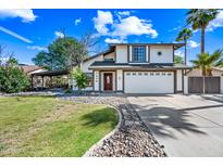 Inviting two-story home with well-manicured lawn, stone accents, and a two-car garage at 7949 W Pershing Ave, Peoria, AZ 85381