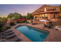 Inviting backyard pool and patio area featuring lounge chairs and lush landscaping, ideal for outdoor relaxation at 8031 N 54Th St, Paradise Valley, AZ 85253