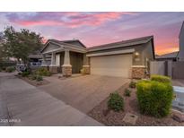 Charming single-story home featuring a large driveway, two-car garage, and meticulously landscaped front yard at 9853 E Solstice Ave, Mesa, AZ 85212