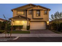 Two-story home features attached two car garage, stucco facade, and manicured front yard at dusk at 9911 E Telemetry Dr, Mesa, AZ 85212