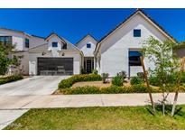 Beautifully landscaped new construction home features a two-car garage and white exterior at 10156 E Talon Ave, Mesa, AZ 85212