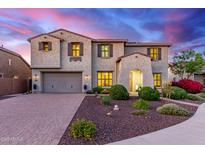 Charming two-story home featuring a well-manicured front yard and a two car garage at dusk at 11844 W Nadine Way, Peoria, AZ 85383
