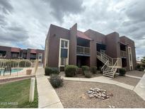Well-maintained building exterior boasts desert landscaping, pool, and charming architectural details at 16602 N 25Th St # 217, Phoenix, AZ 85032