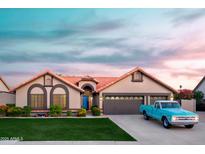Charming single-story home with a blue door, lush lawn, mature plants and an attached two-car garage at 2917 E Northridge St, Mesa, AZ 85213