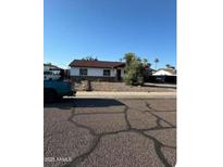 Charming single-story home with a well-maintained front yard and a classic design under a clear blue sky at 2926 E Corrine Dr, Phoenix, AZ 85032