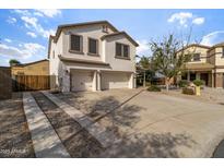 Two-story home featuring a stucco exterior, attached two-car garage, and a concrete driveway at 3491 N 301St Dr, Buckeye, AZ 85396