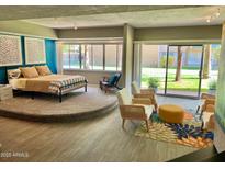 Bright bedroom with a sitting area and a large window with views of the outside at 351 E Thomas Rd # D106, Phoenix, AZ 85012