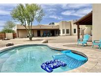 Backyard pool with floaties and lounge chairs next to a charming stucco home with blue skies at 36721 N 17Th Ave, Phoenix, AZ 85086