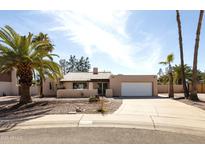 Charming single-story home with a desert-landscaped yard, a two-car garage, and mature palm trees at 4317 E Ludlow Dr, Phoenix, AZ 85032