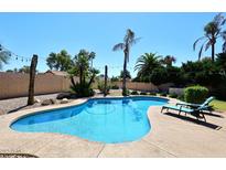 Inviting backyard pool area with lounge chairs and mature palm trees for a relaxing outdoor experience at 4609 E Monte Cristo Ave, Phoenix, AZ 85032