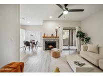 Bright living room featuring a decorative fireplace, modern furniture, and access to outdoor patio space at 9600 N 96 Th St # 130, Scottsdale, AZ 85258