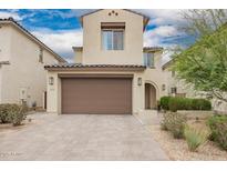 Two-story home with a tan exterior, brown garage door, desert landscaping, and a tile roof at 10050 E Texas Ave, Mesa, AZ 85212
