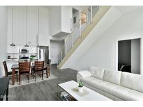 Bright open-concept living space featuring sleek, modern design with hardwood floors, stainless steel railings, and a crisp, white color scheme at 1130 N 2Nd St # 401, Phoenix, AZ 85004