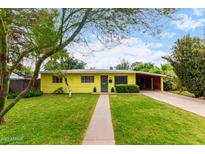 Charming yellow home features a well-maintained front yard, covered parking, and a welcoming entrance at 1609 E Williams N St, Tempe, AZ 85281
