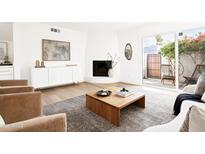 Bright living room featuring a fireplace, stylish decor, and sliding doors to a private patio at 1631 E Gardenia Ave, Phoenix, AZ 85020