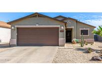 Charming home showcasing a well-manicured desert landscape, complemented by a spacious two-car garage at 1950 E Dust Devil Dr, San Tan Valley, AZ 85143