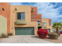 Modern townhome displaying Southwest architecture with a two-car garage and colorful desert landscaping at 7601 E Roosevelt St # 1007, Scottsdale, AZ 85257