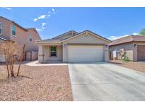 Charming single-story home with a two-car garage, concrete driveway, and desert landscaping at 809 W Kingman Dr, Casa Grande, AZ 85122