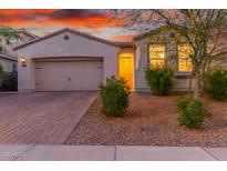 Charming single-story home featuring a two-car garage and attractive desert landscaping at 13720 W Amberwing St, Peoria, AZ 85383