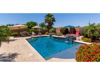 Inviting backyard pool with lush landscaping and multiple seating areas for relaxing and entertaining at 16280 W Durango St, Goodyear, AZ 85338
