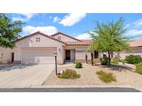 Charming single-story home showcasing desert landscaping, a tile roof, and an attached two-car garage at 19523 N Carriage Ln, Surprise, AZ 85374