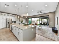 Bright living room showcasing an open floor plan, modern finishes, and seamless indoor-outdoor flow to a covered patio at 25326 N 19Th Dr, Phoenix, AZ 85085